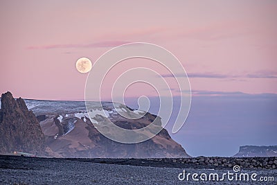 Sunset and moon rise over mountains and Vikâ€™s black sand beach in Iceland Stock Photo